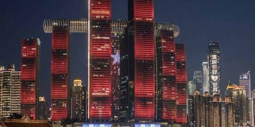 Raffles City Chongqing towers at Chaotianmen lit up at night, with the Crystal skybridge on top