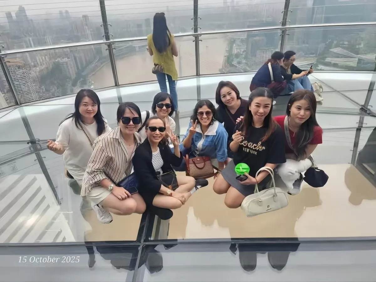 Travellers on the Raffles City "Crystal" glass skywalk over the Chongqing rivers
